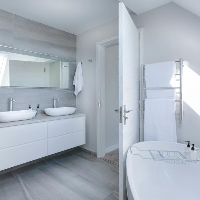 Sleek contemporary bathroom with bathtub and twin sinks, showcasing minimalist design and luxury.