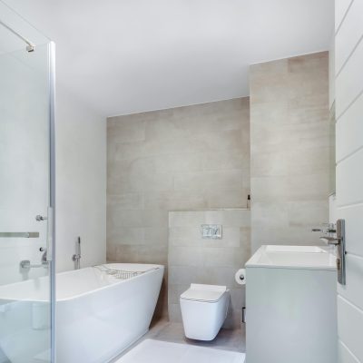 Elegant minimalistic bathroom featuring bathtub and sleek fixtures.