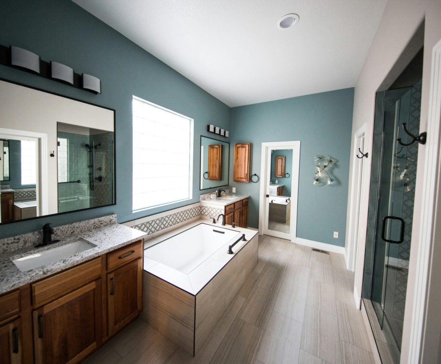 Spacious modern bathroom featuring a freestanding bathtub, wooden cabinets, and granite countertops.