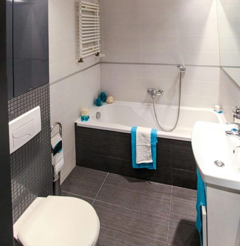 Contemporary bathroom featuring a sleek white bathtub, modern fixtures, and minimalist interior design.